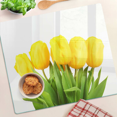 Edzett üveg vágódeszka Sárga tulipánok zöld háttér előtt