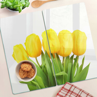 Edzett üveg vágódeszka Sárga tulipánok zöld háttér előtt