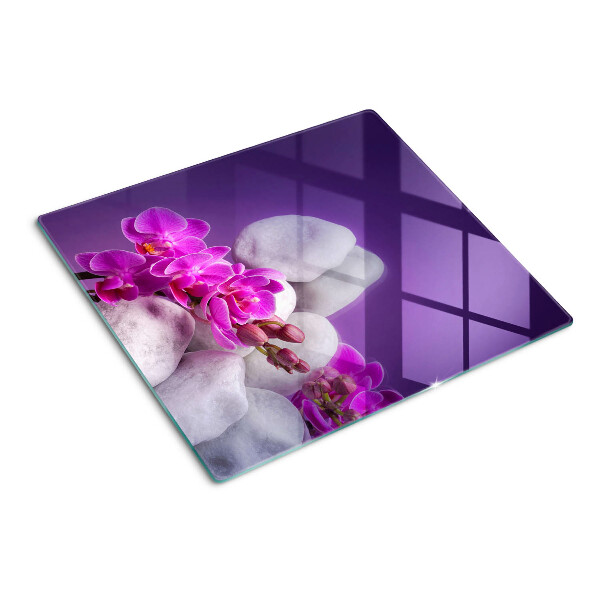 Üveg vágódeszka Orchidea virágok kövek hátterében