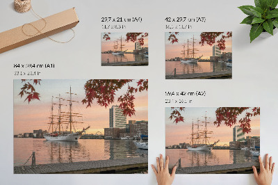 Poszter Egy vitorlás hajó naplementekor, a város békés panorámája