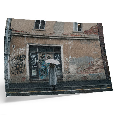 Poszter Egy esernyős személy egy graffitivel teli fal előtt