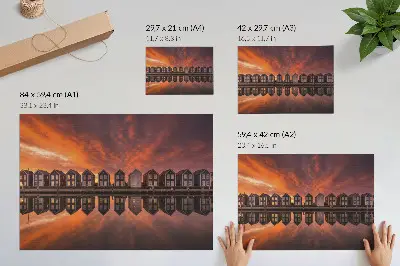 Poszter színes házak a vízparton naplementében